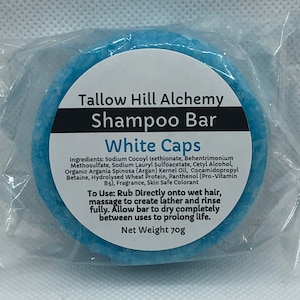 May include: A blue shampoo bar labeled "Tallow Hill Alchemy Shampoo Bar White Caps" with a list of ingredients and instructions for use. The bar weighs 70 grams.