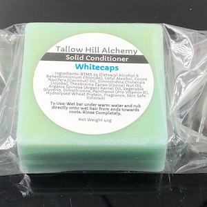 May include: A light green bar of solid conditioner labeled "Tallow Hill Alchemy Solid Conditioner Whitecaps". The ingredients and instructions for use are listed on the label. The bar weighs 40g.