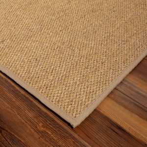 Peut inclure: Un tapis rectangulaire pr&eacute;sentant une texture en fibres naturelles de couleur beige avec un tissage serr&eacute; et r&eacute;gulier. Le tapis est dot&eacute; d'une bordure en tissu assorti de couleur beige clair qui longe le bord droit et net du mat&eacute;riau.