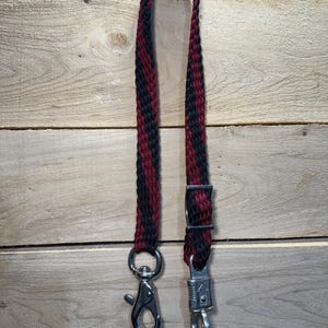 May include: A black and burgundy braided rope halter with a silver snap hook and a silver trigger snap.