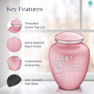 May include: A pink cremation urn with a threaded screw top lid, hand-applied pearl finish, and a felt base. The urn features a butterfly design and is engraved with "In Loving Memory Christy Burke 5/31/1951-8/2/2016".