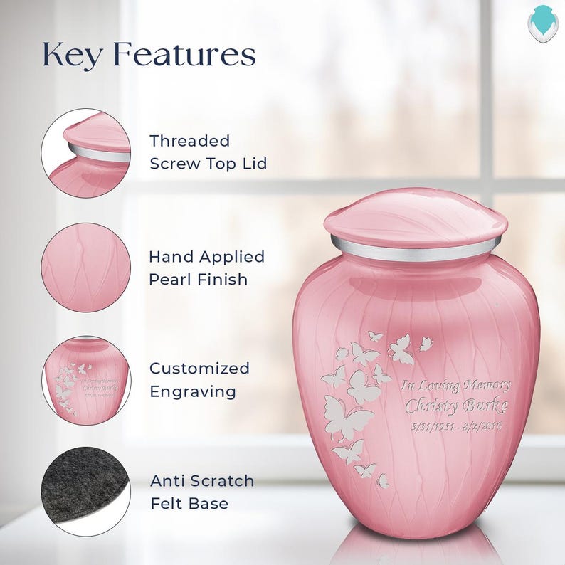 May include: A pink cremation urn with a threaded screw top lid, hand-applied pearl finish, and a felt base. The urn features a butterfly design and is engraved with "In Loving Memory Christy Burke 5/31/1951-8/2/2016".
