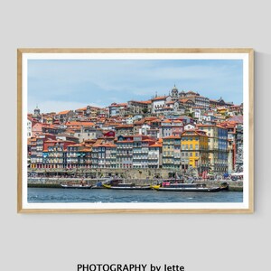 May include: A colorful cityscape with buildings lining a waterfront. The buildings are a mix of red, yellow, and orange, and there are several boats in the water.
