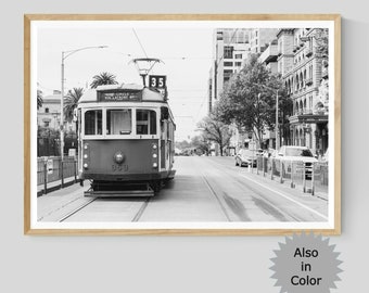 May include: Black and white photograph of a vintage streetcar traveling down a city street. The streetcar is labeled "35" and has the number "999" on the side. The streetcar is surrounded by buildings and trees.