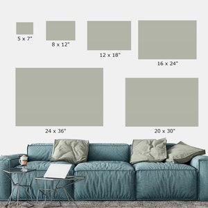 May include: A mockup of different sized prints of a muted green color on a white wall above a blue sofa. The prints are labeled with their dimensions in inches. The smallest print is 5 x 7 inches, the largest is 24 x 36 inches.