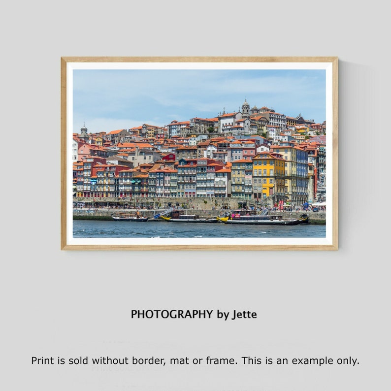 May include: A colorful cityscape with buildings lining a waterfront. The buildings are a mix of red, yellow, and orange, and there are several boats in the water.