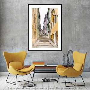 May include: A narrow, cobblestone street in a European city with colorful buildings on either side. The street leads up a set of stairs to a building with a sign that reads "Casa da Musica".