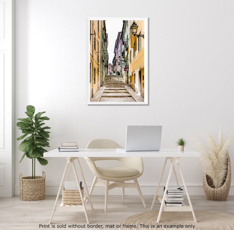 May include: A narrow, cobblestone street in a European city with colorful buildings on either side. The street leads up a set of stairs.