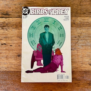 May include: A comic book cover featuring a green clock face with Roman numerals and two figures. The figures are a man in a dark suit and a woman in a pink shirt. The comic book is titled "Birds of Prey" and is issue number 49.
