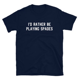 May include: Navy blue t-shirt with the white text "I'D RATHER BE PLAYING SPADES". The short-sleeved shirt is made of a soft material. The text is centered on the front of the shirt.