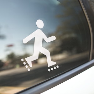 May include: A white sticker of a person rollerblading on the back window of a car.
