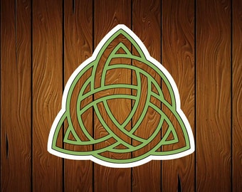 May include: A green Celtic knot design in the shape of a triangle, with a white outline, against a brown wood background.
