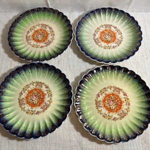 May include: Set of four vintage floral patterned plates with green and blue scalloped edges and gold accents.