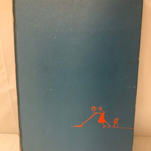 May include: A blue hardcover book with a red illustration of a person pushing a lawnmower and a small dog standing behind them.