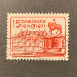 May include: Red and white Danish postage stamp with the text "15 DANMARK 1912 1937" and "AMALIENBORG". The stamp features a building and a rider on horseback.