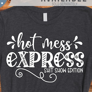 May include: A black and white graphic design with the text "hot mess express shit show edition" on a wood background. A dark grey t-shirt with the same design is shown below.
