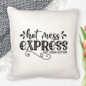 May include: White throw pillow with black text that reads "hot mess express" and "shit show edition".