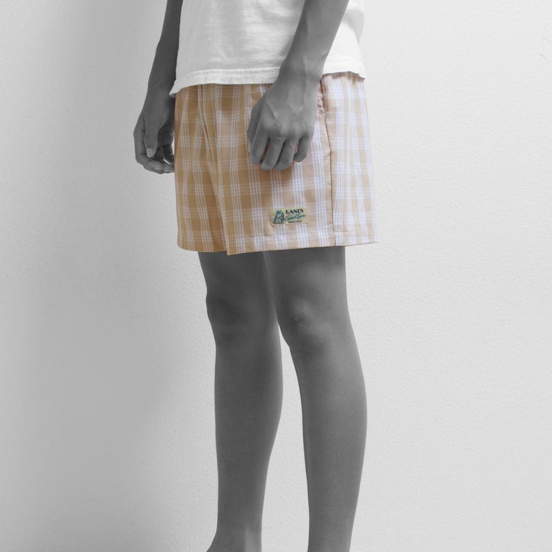 May include: Beige and white checkered shorts with a small green and white logo that says "Lans' End" on the right leg.