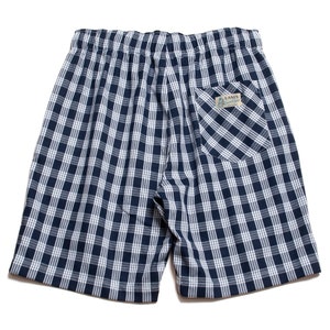 May include: Blue and white plaid shorts with an elastic waistband and a back pocket. The shorts have a label that says "Lannis" on the back pocket.