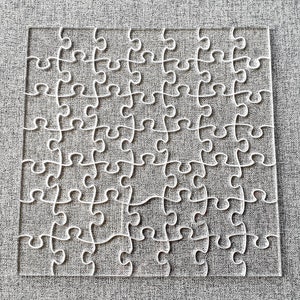 Puede incluir: Un rompecabezas blanco con un diseño simple e interconectado. El rompecabezas está ensamblado y listo para ser disfrutado.