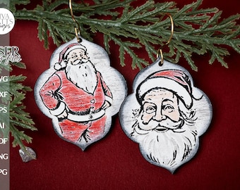 Puede incluir: Dos adornos navideños de madera con ilustraciones vintage de Papá Noel. Un adorno muestra el cuerpo completo de Papá Noel, mientras que el otro muestra un primer plano de su rostro. Ambos adornos tienen un fondo blanco con contornos negros y acentos rojos.