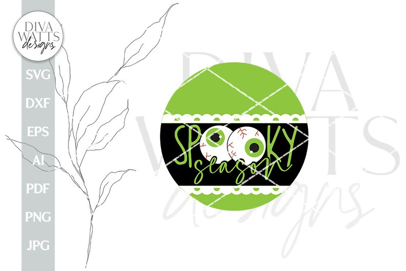 May include: A green and black circle with a white lace trim. The circle has two googly eyes and the text "Spooky Season" in black.