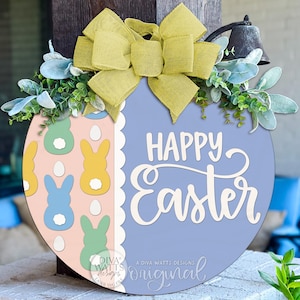 May include: Round wooden Easter sign with a light blue background and the words "Happy Easter" in white script. The left side features pastel-colored bunnies and eggs. The sign is decorated with a yellow bow and greenery.