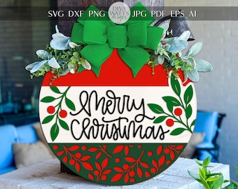 May include: A round Christmas door hanger with a red and white design, green bow, and greenery. The words "Merry Christmas" are written in black script. The bottom of the hanger has a green and red leaf pattern.
