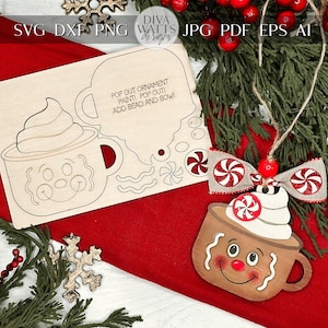 May include: A wooden craft kit for making a hot chocolate mug ornament. The kit includes a pre-cut wooden mug shape, a separate piece for the whipped cream, and candy pieces for decoration. The instructions say "Pop out ornament, paint, pop out, add bead and bow!"