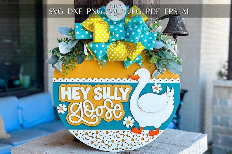 May include: A round wooden sign with a blue and yellow background. The sign features a white goose with the text "Hey Silly Goose" in white and yellow letters.