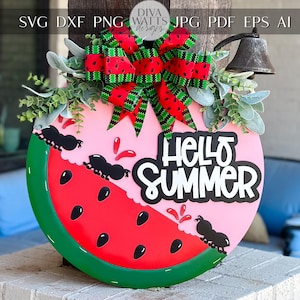 Puede incluir: Un colgador de puerta en forma de sandía rosa y verde con el texto "Hello Summer" y un lazo rojo y verde. El colgador de puerta está decorado con hormigas negras y semillas de sandía rojas.