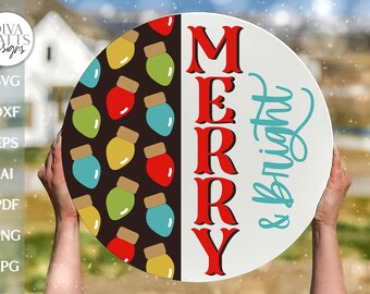 May include: A round wooden sign with the words "Merry & bright" in red and teal lettering. One half of the sign features a pattern of colorful light bulbs on a black background.