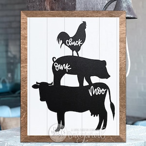 May include: Wooden framed farmhouse sign with a white background and black silhouettes of a cow, pig, and rooster stacked on top of each other. The cow has the word "Moo", the pig has the word "Oink", and the rooster has the word "Cluck".
