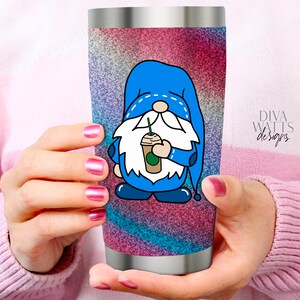 May include: A stainless steel tumbler with a colorful glitter design featuring a blue gnome holding a coffee cup. The gnome has a white beard and a blue hat with white stitching. The text "Diva Watts Designs" is visible on the tumbler.