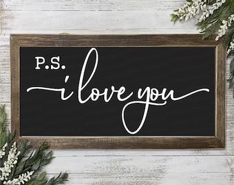 May include: A black framed sign with a white background and the text "P.S. i love you" in a cursive font.
