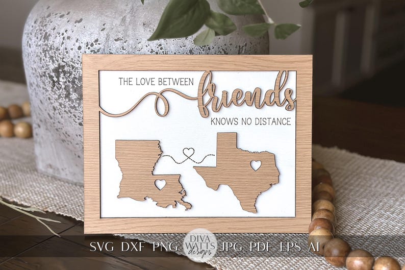 May include: A wooden sign with the text "The love between friends knows no distance" and a map of Louisiana and Texas with hearts connecting them.