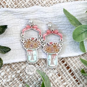 Digital SVG File Instant Download Featuring Dangle Earrings With Bow Frame And Mason Jar Floral Design For Laser Cut Jewelry Making, Delicate Layered Earring Template SVG Ideal For Handmade Boutique Earrings And Small Business Production, Clean Cut Paths For Laser Machines, Perfect For Creating Lightweight Statement Or Everyday Earrings From A Single SVG File Only
