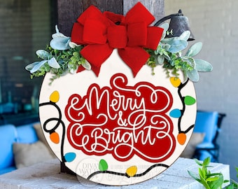 May include: Round wooden sign with the text "Merry & Bright" in red and white script. The sign is decorated with a large red bow, greenery, and colorful string lights, perfect for holiday decor.