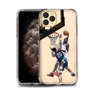 May include: A clear phone case with a basketball player in a blue and white jersey making a slam dunk. The player is wearing red shoes and the background is a basketball court with a hoop and net. The case has a gold trim and the words "SportCases" are printed on the bottom right corner.