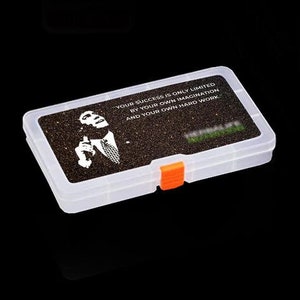 Op de afbeelding: Een transparante plastic opbergdoos met een zwart-wit afbeelding van een man met de quote "Je succes wordt alleen beperkt door je eigen verbeelding en je eigen harde werk."