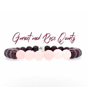 Puede incluir: Un brazalete hecho con cuentas de granate y cuarzo rosa. El brazalete tiene un dije de plata en el centro.