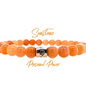 May include: A bracelet made of orange sunstone beads with a silver charm that says "Personal Power".