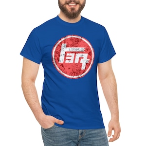 Puede incluir: Una camiseta azul real con un círculo rojo desgastado que contiene un logotipo blanco de Toyota. El logotipo es una "T" estilizada con dos líneas horizontales.