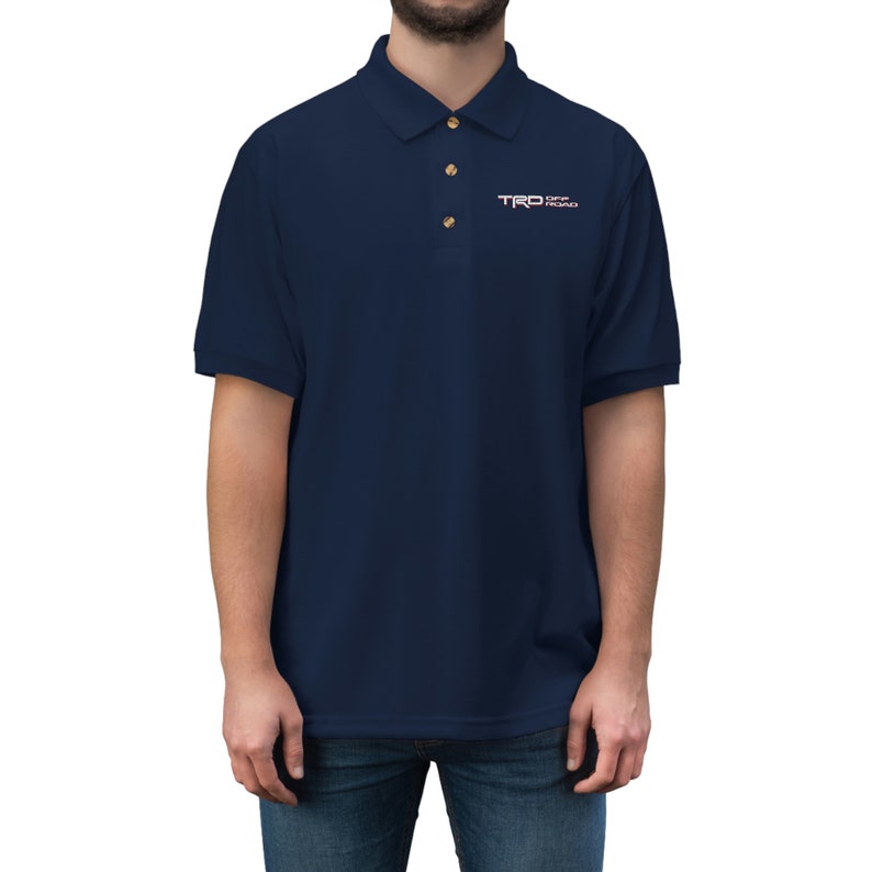May include: A navy blue polo shirt with a small embroidered logo that says "TRO Off Road" in white and red lettering.