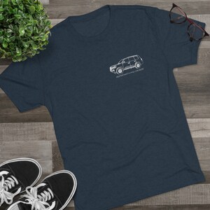 K&ouml;nnte beinhalten: Ein dunkelblaues T-Shirt mit einer wei&szlig;en Umrandung eines Toyota Land Cruiser und dem Text "#EEFMOMENTSLANDCRUISER" auf der Vorderseite.