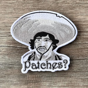 Könnte beinhalten: Gestickter Aufnäher mit einem Cartoon-Mann mit Sombrero und dem Text "Patches?" in einer stilisierten Schriftart. Der Aufnäher ist hauptsächlich schwarz, weiß und grau, mit detaillierten Stickereien.