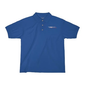 May include: A royal blue polo shirt with a small embroidered logo on the left chest. The logo is in white and pink and says "TRPX".
