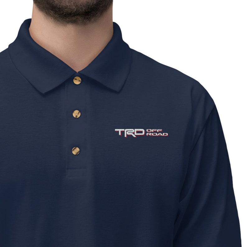May include: A navy blue long-sleeve polo shirt with a white embroidered logo that says "TRD OFF ROAD".