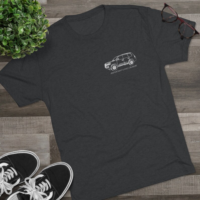 K&ouml;nnte beinhalten: Ein dunkelgraues T-Shirt mit einer wei&szlig;en Umrandung eines Land Cruiser SUV und dem Text "Jeepmonkey Land Cruisers".