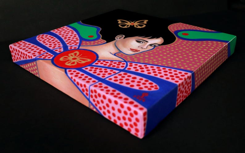 May include: A square canvas painting featuring a stylized portrait of a person with dark hair, accented by a gold butterfly motif. The composition incorporates vibrant pink, blue, and green geometric patterns with red polka dots and a central red circle.